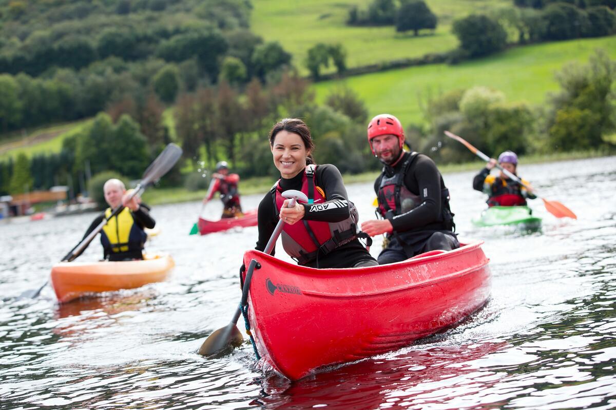 A woman smiling while canoeing with a group on Lough Derg near Killaloe, Co Clare